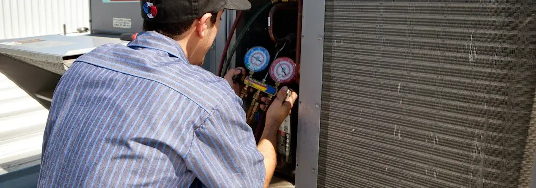 HVAC technician servicing a condenser unit in Fort Pierce North
