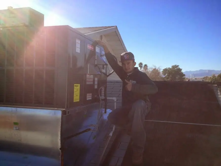 HVAC technician performing AC Tune-Up on a rooftop unit in Fort Pierce North